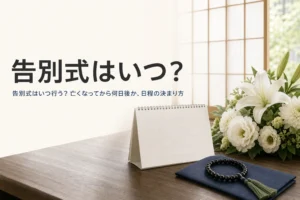 告別式はいつ行うのかを紹介する記事のアイキャッチ。文机の上の卓上カレンダーと白い花、数珠
